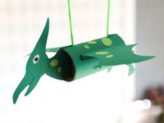 a green paper fish hanging from a string