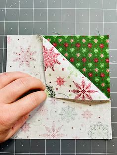 someone is making a christmas ornament out of fabric on a piece of paper