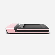 a pink and black electronic device sitting on top of a white surface with a gray background