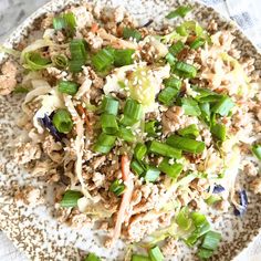 a white plate topped with meat and veggies on top of a marble table