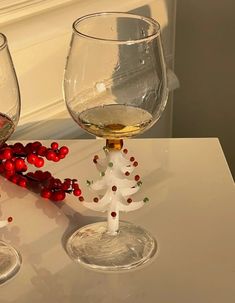 two wine glasses sitting on top of a table next to a christmas tree ornament