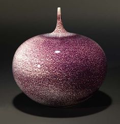 a purple vase sitting on top of a table