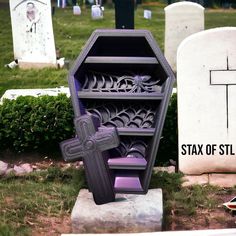 a purple book shelf sitting in the middle of a cemetery with a cross on it