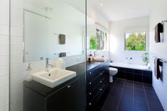 a modern bathroom with black and white tile flooring