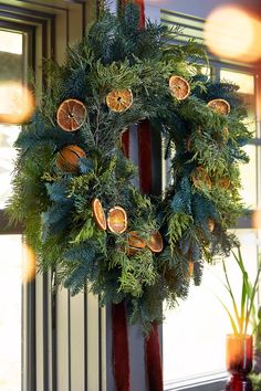 a christmas wreath with oranges hanging from it