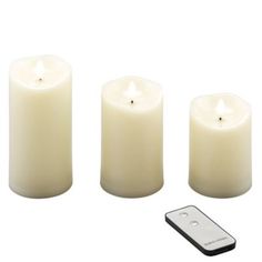 three white candles and a remote control