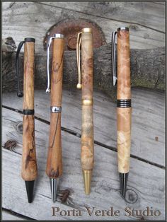 four different types of pens sitting on top of a wooden table