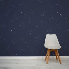 a white chair sitting in front of a wall with stars painted on it and a dark blue background