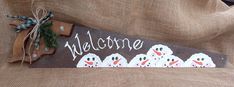 a welcome sign with snowmen painted on it and the word welcome written in white