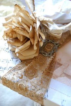 a piece of cloth and lace on top of an old paper doily with a flower in the middle