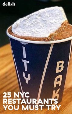 there is a cup with some food in it on top of a wooden table and the words 25 nyc restaurants you must try