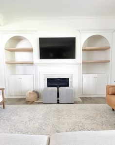 a living room with two couches and a television mounted on the wall above it