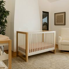 a white crib sitting in the corner of a living room