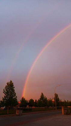 two rainbows in the sky over a street