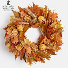 a wreath with oranges and leaves on it