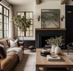 a living room filled with furniture and a fire place in front of a large window