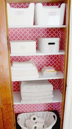 an organized closet with white baskets and toilet paper