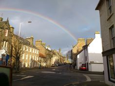 a rainbow is in the sky over some buildings