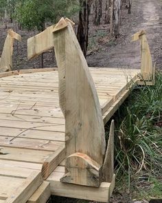 two ducks are standing on a wooden bridge in the woods