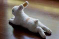 a white stuffed animal laying on top of a wooden floor