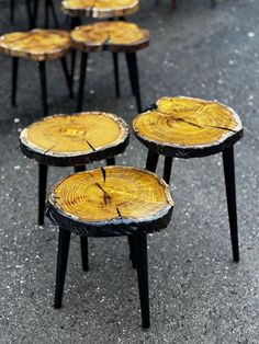 several tables made out of tree trunks sitting on the ground in front of each other