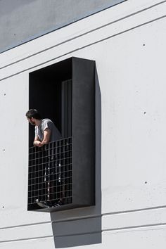 a man standing in the window of a building