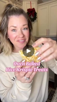 a woman holding up a piece of food in her hands with the words oven baked rice krispy treats on it