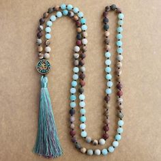 Using a combination of the Picture Jasper, the Picasso Jasper and the marvelous Amazonite stone, the Amazonite Multi Gemstone Hum Mala beads is all you need to work on your spiritual growth and transformation. Jasper gemstones are known for their ability to enhance energy flow within the body and that is exactly what the picture Jasper and Picasso Jasper help you achieve. In particular, the Picture Jasper helps nurture your spirit while the Picasso Jasper encourages optimism and creativity. Tassel Necklace Boho, Green Amazonite, Diy Collier, Amazonite Necklace, Bracelet Pandora, 108 Mala Beads, Necklace Collection, Long Beaded Necklace