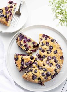 blueberry cheesecake cut into slices on a white plate with a fork next to it