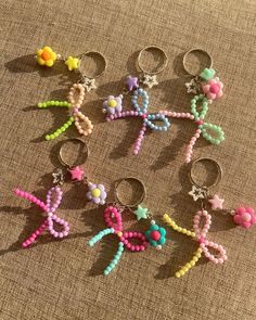 six pairs of beaded key chains on a brown surface