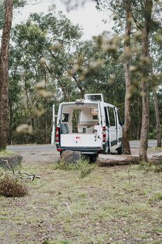 a white van is parked in the woods