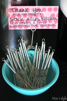 a blue bowl filled with lots of silverware and a sign that says thank you for helping the stock alles kitchen