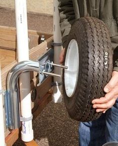 a man is holding a large tire in his hand