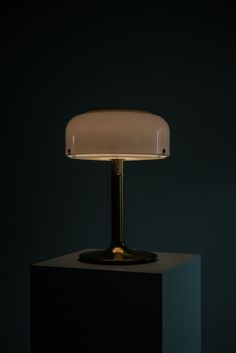 a table lamp sitting on top of a black box with a white light in the middle