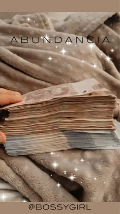 a person is holding an open book on top of a blanket with stars in the background