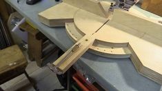 a wooden clock is being built on a workbench