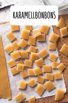 some pieces of cheese are on a cutting board with the words karemelbons above it