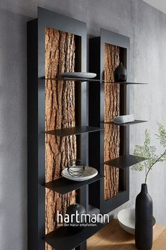 a table with a vase and plates on it next to a book shelf filled with books