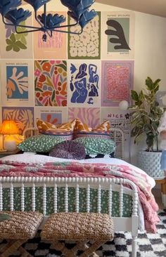 a bed with colorful pillows and blankets on top of it in front of a wall