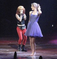 two women on stage with microphones in their hands