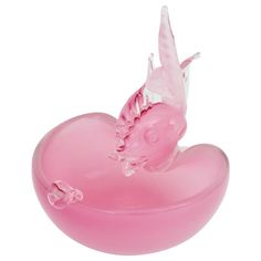 a pink glass bowl with a bird on it