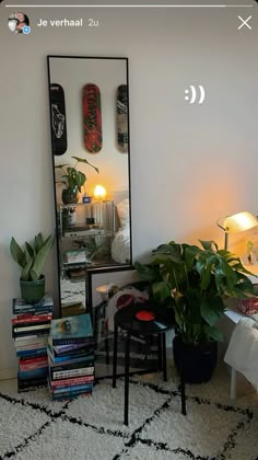 a mirror sitting on top of a floor next to a table with books and plants