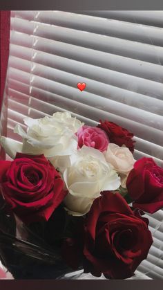 red and white roses in a vase on a windowsill with a heart shaped window sill