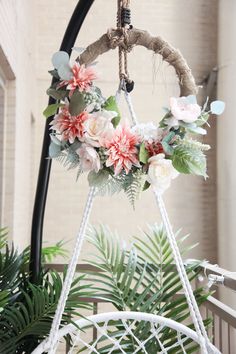 a white hammock with flowers and greenery hanging from it