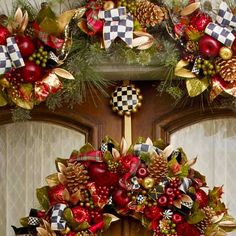 a christmas wreath is hanging on the front door with ornaments around it and pine cones