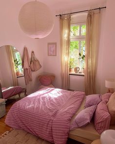 a bed room with a neatly made bed next to a window and a mirror on the wall