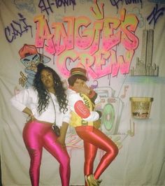 two young women posing in front of a graffiti covered wall with the words anger crew on it