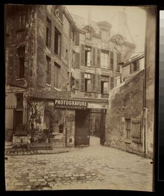 an old photo of a building with a sign on it's front door that says photographware