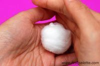 a hand holding a cotton ball in it's palm