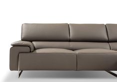 a grey leather couch sitting on top of a white floor